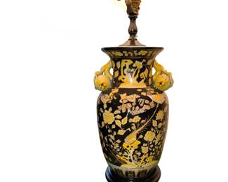 vintage Asian-style famille noir ceramic table lamp with a black background and yellow floral and bird motifs, mounted on a dark wooden base.