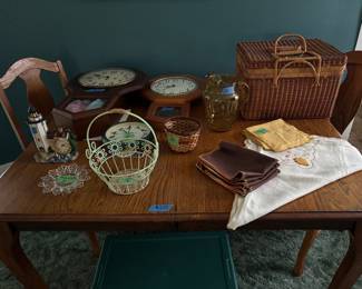Antique oak dinning table with two leaves (this table was refinished in the 60’s.  The leaves are still in the original dark finish, still has  original wooden wheels ), vintage table linens, clocks, glassware and basket