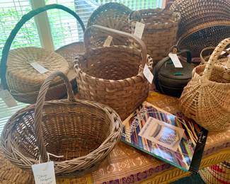 two huge tables filled with all types of antique baskets