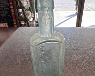 The bottle in the image is an antique medicine or apothecary bottle from Gustavus J. Luhn, a prominent late 19th-century pharmacist based in Charleston, South Carolina.