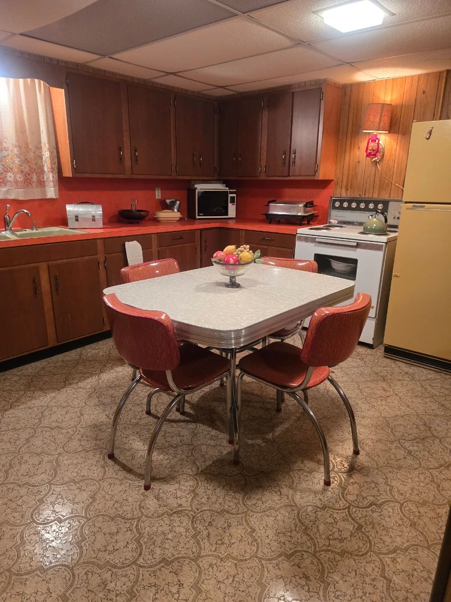 Gorgeous chrome dinette with orange chairs and white table top