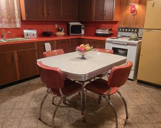 Gorgeous chrome dinette with orange chairs and white table top