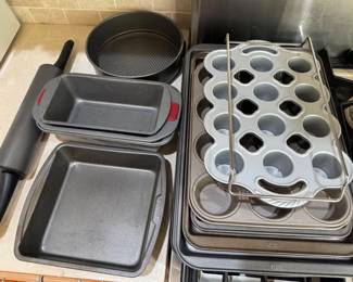 Large assortment of bakeware, cookie sheets, muffin pan, cake pans and a rolling pin