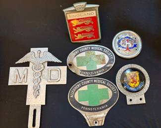 Collection of vintage automobile badges and license plate toppers