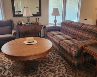 plaid upholstered couch, round coffee table, drop leaf table, rocker/recliner