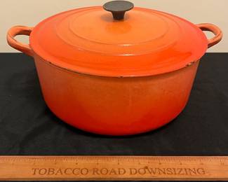 O85 - $30. Le Creuset Flame Orange “E” 4.5 Qt Dutch Oven. Lid has chips -inside is dark.