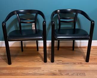 O123 - $75. Pair of Black chairs. Leather Seats. Each Measures 22.5" W x 19" D x floor to seat 17" x floor to back 28" Tall. Both show signs of wear and one seat is damaged on a corner.