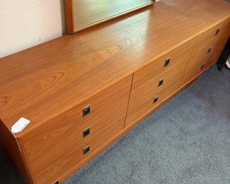 O41 - $275. 9 Drawer Long Dresser. Teak Veneer - Made in Canada. Measures 72” W x 18” D x 27” Tall. Mirror Measures 29.25“ W x 41.25” Tall. All drawers slide - top is in very good condition.