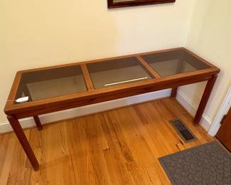 O2 - $250. MCM Danish Teak Console Table with Smokey Glass Panels. Measures 59” W x 19” D x 25.25” Tall. Bottoms of legs show wear.