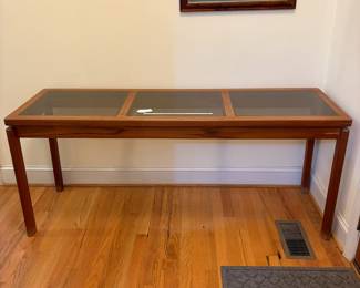 O2 - $250. MCM Danish Teak Console Table with Smokey Glass Panels. Measures 59” W x 19” D x 25.25” Tall. Bottoms of legs show wear.