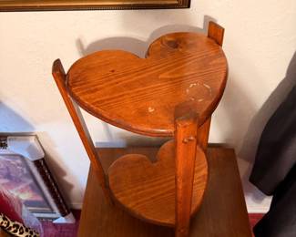 Vintage Heart-Shaped Wood Plant Stand – Charming two-tier wooden plant stand featuring heart-shaped shelves and a warm stained finish. Perfect for displaying plants, figurines, candles, or decorative accents in a country, cottage, or rustic-style home. A unique vintage accent piece. Sold as found.