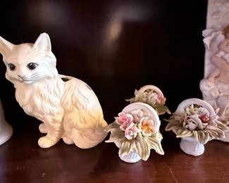 Decorative Cat Planter & Floral Porcelain Collection – Charming assortment featuring a white ceramic cat planter, delicate porcelain floral basket figurines, and a cherub picture frame. A lovely collection for cottage, shabby chic, or garden-inspired décor. Sold individually unless noted.