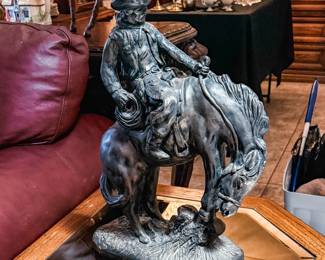 Bronze-Tone Cowboy on Horse Sculpture – Impressive Western-style sculpture depicting a cowboy riding horseback with finely detailed tack, clothing, and realistic horse features. Finished in a classic bronze-tone patina, this striking piece makes a wonderful statement for Western, ranch, rustic, or Southwestern décor. A great addition to any cowboy or equestrian collection. Sold as found.