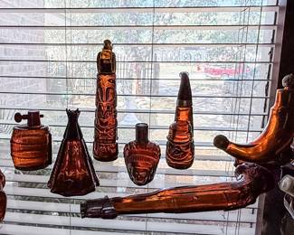 Vintage Brown Glass Barware Collection – Assorted vintage amber/brown decorative glass bottles and decanters, including tiki-inspired designs and a novelty pipe-shaped decanter. A unique collection for barware enthusiasts, mid-century décor, or vintage glass collectors. Sold individually unless noted.