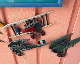 Vintage Aviation Wall Décor Collection – Patriotic aviation-themed display featuring a framed "Join the Air Service – Learn & Earn" reproduction poster surrounded by decorative metal biplane wall hangings. A unique collection for aviation enthusiasts, military memorabilia collectors, or vintage-inspired décor. Sold individually unless noted.