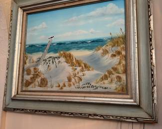 Framed Coastal Landscape Painting – Beautiful framed coastal landscape painting depicting rolling sand dunes, sea oats, and ocean waves beneath a bright blue sky. Finished in an attractive wood frame with soft coastal tones, this artwork is perfect for a beach house, coastal-inspired home, or anyone who loves seaside décor. Ready to hang.
