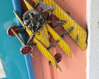 Vintage Aviation Wall Décor Collection – Patriotic aviation-themed display featuring a framed "Join the Air Service – Learn & Earn" reproduction poster surrounded by decorative metal biplane wall hangings. A unique collection for aviation enthusiasts, military memorabilia collectors, or vintage-inspired décor. Sold individually unless noted.