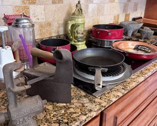 Assorted Kitchenware & Cast Iron Collection – Selection of cookware and kitchen accessories including cast iron cookware, nonstick pots and pans, cast iron meat grinder, mortar and pestles, stoneware stein, baking pans, and assorted kitchen tools. Great mix for everyday cooking or vintage kitchen collections. Sold individually unless noted.