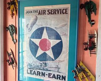 Vintage Aviation Wall Décor Collection – Patriotic aviation-themed display featuring a framed "Join the Air Service – Learn & Earn" reproduction poster surrounded by decorative metal biplane wall hangings. A unique collection for aviation enthusiasts, military memorabilia collectors, or vintage-inspired décor. Sold individually unless noted.