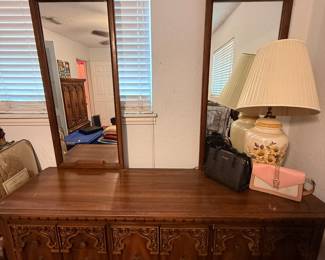 Vintage Carved Wood Dresser with Twin Mirrors – Beautiful vintage dresser featuring richly carved cabinet doors and decorative hardware, topped with matching dual framed mirrors. Offers ample concealed storage and timeless traditional styling. A stunning statement piece for a bedroom, entryway, or dining room. Contents not included unless noted.