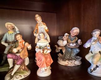Vintage Porcelain Figurine Collection – Elegant assortment of porcelain figurines depicting musicians, villagers, and everyday scenes in beautifully detailed hand-painted finishes. A charming collection for traditional décor, curio cabinets, or porcelain figurine collectors. Sold individually unless noted.