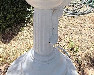 Concrete Cherub Birdbath – Charming cast concrete birdbath featuring a cherub child perched beside a fluted basin atop a classic pedestal base. A beautiful garden accent that's perfect for attracting birds while adding timeless elegance to patios, flower beds, and outdoor landscapes. Sold as found.