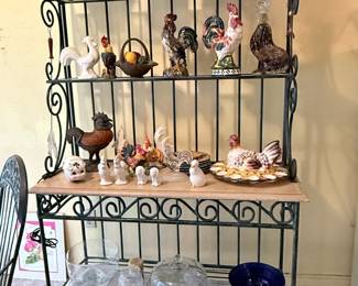 **Large Bakers Rack with Decorative Rooster Collection** – Sturdy metal and wood bakers rack/display shelf featuring multiple tiers. Displayed with an extensive assortment of ceramic rooster figurines, pitchers, baskets, and farmhouse décor (sold separately unless noted). Great for kitchen storage or country-style displays.