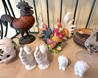**Assorted Rooster & Farmhouse Décor Collection** – Charming assortment of rooster-themed décor including ceramic figurines, frosted glass rooster, cast iron rooster, rooster accent plates, white ceramic birds, lion figurines, and a lucky shamrock piggy bank. Great selection for farmhouse, country, or rooster collectors. Sold individually unless noted.