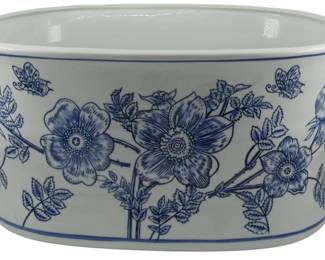 172 - Blue & White Floral Planter 8.5"x18"x13" (Description): Large blue and white ceramic planter featuring a traditional floral and butterfly motif. The oval-shaped vessel is adorned with decorative side handles and displays hand-painted style botanical designs including large blooming flowers, leafy stems,and delicate butterflies. Blue banding accents the rim and base. Measures 8 1/2 inches by 18 inches by 13 inches.