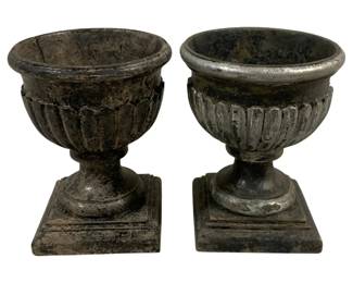 2401 - Pair Decorative Urns 4"x7" (Description): A two-piece set of compotes measuring 4 inches by 7 inches. These decorative vessels feature a classic urn shape with fluted bowls resting on pedestal bases with square footings.