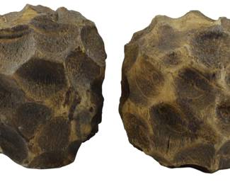 243 - Pr Elk Home Carved Wood Candlestands (Description): A pair of carved wood candlestands featuring a distinctive faceted or honeycomb-like surface pattern. The pieces display natural wood tones in shades of brown with variations in coloring across the carved surfaces. Each candlestand has an organic, roughly spherical form with multiple carved indentations creating a textured, geometric appearance.