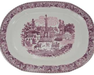177 - Pink & White Porcelain Platter 13"x17" (Description): Pink and white porcelain platter featuring a transferware scenic design depicting a European town square with classical architecture, a central monument column, and figures on horseback. The decorative border showcases a series of medallions with various motifs. Measures 13 inches by 17 inches.