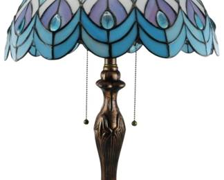 182 - Tiffany Style Peacock Stained Glass Lamp 24" (Description): Tiffany style stained glass table lamp featuring a peacock feather motif shade in shades of blue, purple, and white. The scalloped shade displays an Art Nouveau-inspired design with leaded glass panels. The lamp has a cast metal base with an antiqued bronze finish and decorative foliate detailing. Features dual pull chain switches for operation. Electric/electronic/mechanical item - No