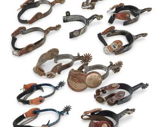 1202 A group of Western spurs 20th century Six pairs of spurs and one single spur, each of various style of heel, shank, and rowel, by various makers including Vogt, E. Garcia, Winchester, and Andrews (Joshua, Tex), most with mixed metal overlay designs, three with chased silver accents, one pair with monogram CR, the Winchester pair with pictorial 'leg' design shanks, and one pair with wide woven leather straps with large chased silver concha style medallions 13 pieces Largest inner heel width 3 1/2 in., shank length 2 1/4 in., rowels diameter 2 1/4 in.; smallest inner heel width 3 in., shank length 1 5/8 in., rowels diameter 1 1/2 in. Estimate: $500 - $800
