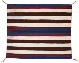 1292 A Navajo first phase wearing blanket-style weaving 20th century Woven in bands of aniline red, blue, natural cream and dark brown wool 4 ft. 9 1/4 in. x 5 ft. 8 3/4 in. Estimate: $800 - $1,200