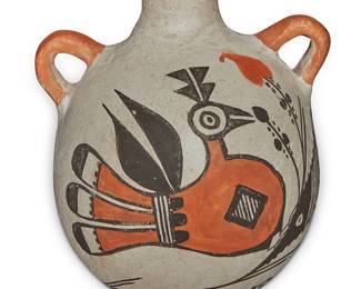 1052 An Acoma Pueblo polychrome pottery canteen Mid-20th century With opposed lug handles, painted with orange and brown bird motif on white slip ground Signed in slip to underside: Acoma / [feather device] Height 4 in., width 4 1/2 in., depth 5 1/4 in. Estimate: $300 - $500