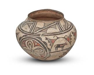 1043 A Zuni Pueblo polychrome pottery jar First half 20th century The three-color olla with red and black alternating registers of heartline deer and floral medallions, flanked above and below by geometric motifs, on white slip ground, above a puki indentation Height 8 3/4 in., diameter 11 3/4 in. Estimate: $1,200 - $1,800