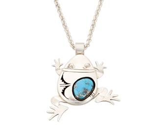 1352 Bennie Ration (b. 1955, Diné [Navajo]) A sterling silver climbing frog figural pendant/brooch with set oblong turquoise stone and incised silver geometric accents, suspended from a silver chain Stamped: B.R. / Sterling / [talon picto] Pendant 2 5/8 x 2 in., chain 22 1/4 in. 46.3 grams gross Estimate: $500 - $700