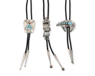 1328 Three Diné (Navajo) or Hopi silver bolo ties Mid/late 20th century Featuring a trio of figural bolos in silver including a sculptural sterling silver overlay katsina motif bolo, a Mabel Kee Diné sterling silver heartline bear with set blue stones, and a Willie Nezzie Diné tipi-motif silver metal bolo with chipped stone mosaic inlay, each mounted on a braided black leather cord with silver metal cone tips Each variously marked for maker and for sterling: HC [conjoined, for Hopi Crafts] / MK [for Mabel Kee, Diné (Navajo)] / WN [for Willie Nezzie, b. 1950, Diné (Navajo)] 3 pieces Bolos 3 1/4 x 1 in. to 1 7/8 x 1 38 in.; cords 38 to 37 in. 107.0 grams gross Estimate: $200 - $400