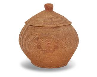 1170 A large Paiute polychrome storage basket Second quarter 20th century; Great Basin A large polychrome coiled globular basketry jar with large shaped knobbed lid, featuring four polychrome stylized floral motifs to sides and similar motifs to sides of lid, the lid with colored top knob Height 14 in., diameter 13 1/2 in., approximately Estimate: $400 - $600