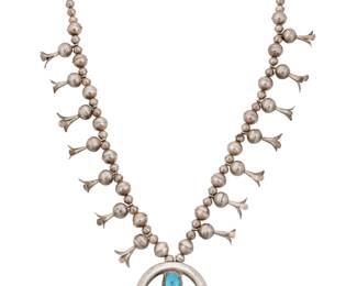 1392 A Southwest sandcast silver squash blossom necklace Mid-20th century A single strand silver bead necklace with fourteen blossom beads, all suspending a sandcast naja with central set turquoise Unmarked 30 1/2 x 2 3/4 in. 130.5 grams gross Estimate: $200 - $300