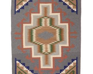 1290 A Diné (Navajo) regional rug Late 20th century Woven in grey, green, blue, tan, and salmon pink wool with central multicolored sawtooth and stepped hooked diamonds, with stepped motifs to each corner 3 ft. 8 1/2 in. x 2 ft. 9 1/2 in. approximately Estimate: $300 - $500