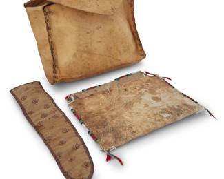 1114 Two Plains hide bags Early 20th century Comprising a Lakota (Sioux) beaded hide flat pouch with polychrome striped beaded edges and tin cone and dyed horsehair dangles to corners enclosing a trade cloth roll with pockets, together with a large parfleche bag with top flap and partial strap to back side 2 pieces The first 9 3/4 x 12 in.; the second height 12 in., width 11 in., depth 4 1/2 in. Estimate: $300 - $500