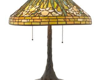 1243 A Tiffany-style glass and metal 'Daffodil' table lamp Late 20th century, Gunther Lambert Collection The leaded glass shade depicting floral motifs, on a patinated bronze Gunther Lambert Collection lamp base issuing three lights, electrified Base marked in the casting in relief: GUNTHER LAMBERT COLLECTION; shade unmarked Height of base 25 in., diameter 9 3/4 in.; height of shade 8 3/4 in., diameter 20 in. Estimate: $1,000 - $2,000