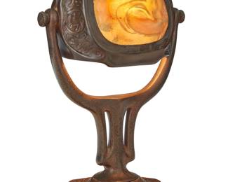 1094 A Tiffany Studios turtleback tile 'Zodiac' table lamp Early 20th century The patinated bronze base with zodiac symbols in low relief, issuing an articulated shade with molded iridescent glass and single light, electrified Impressed to underside: TIFFANY STUDIOS / NEW YORK / 541 Height 14 7/8 in., width 9 7/8 in., depth 6 1/4 in. Estimate: $5,000 - $8,000