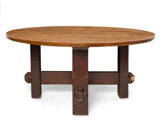 1191 A large Arts & Crafts oak dining table Early 20th century, possibly Charles Stickley (1860-1927) With a quarter-sawn oak tabletop raised on exaggerated cross stretchers with large keyed tenon joinery Appears unmarked Height 30 in., diameter 65 in. Estimate: $1,000 - $1,500