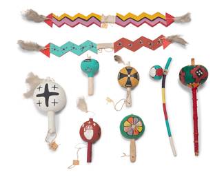 1022 A group of Hopi polychrome dance implements Mid-20th century Comprising six painted wood or gourd rattles, two painted carved wood lightning sticks, and a carved painted dance rod with a painted cloth ball, some mounted with feather accents 9 pieces Longest rattle height 18 in., diameter 5 in; shortest height 8 in., diameter 3 3/4 in.; longest stick height 28 in., width 3 1/2 in., depth 1/2 in. Estimate: $300 - $500