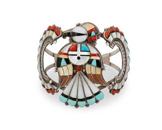 1333 Verdel & Esther Niiha (20th/21st century, Zuni) An elaborate two-wire multistone inlay Thunderbird cuff bracelet including turquoise, mother of pearl, coral, and other shells, with a central Sunface motif and curved wing plaques to shoulders Etched signatures verso; further etched: Zuni / N. Mex. 6 1/2 in. total inner C x 2 1/2 in., including a 1 in. gap 50.4 grams gross Estimate: $300 - $500