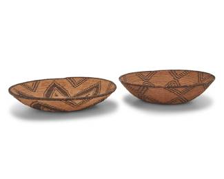 1172 Two Western Apache basketry trays Early 20th century; Southwest United States Each large coiled low bowl with stepped motifs including one with a central concentric star/flower motif with floating elements and the other with an interlocking radiating floral/star design and dark center 2 pieces Larger height 3 in., diameter 15 1/4 in.; smaller height 4 in., diameter 14 3/4 in. Estimate: $1,200 - $1,800
