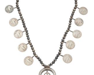 1390 A Southwest sterling silver squash blossom coin necklace Mid-20th century A single strand sterling silver bead necklace with ten 1920s Liberty quarter coin 'blossoms' suspending a cast sterling silver naja Unmarked 24 x 1 7/8 in. 118.0 grams gross Estimate: $300 - $500